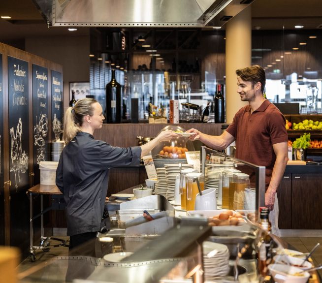Breakfast buffet at St. Martins Lodge Waitress gives guest his eggs