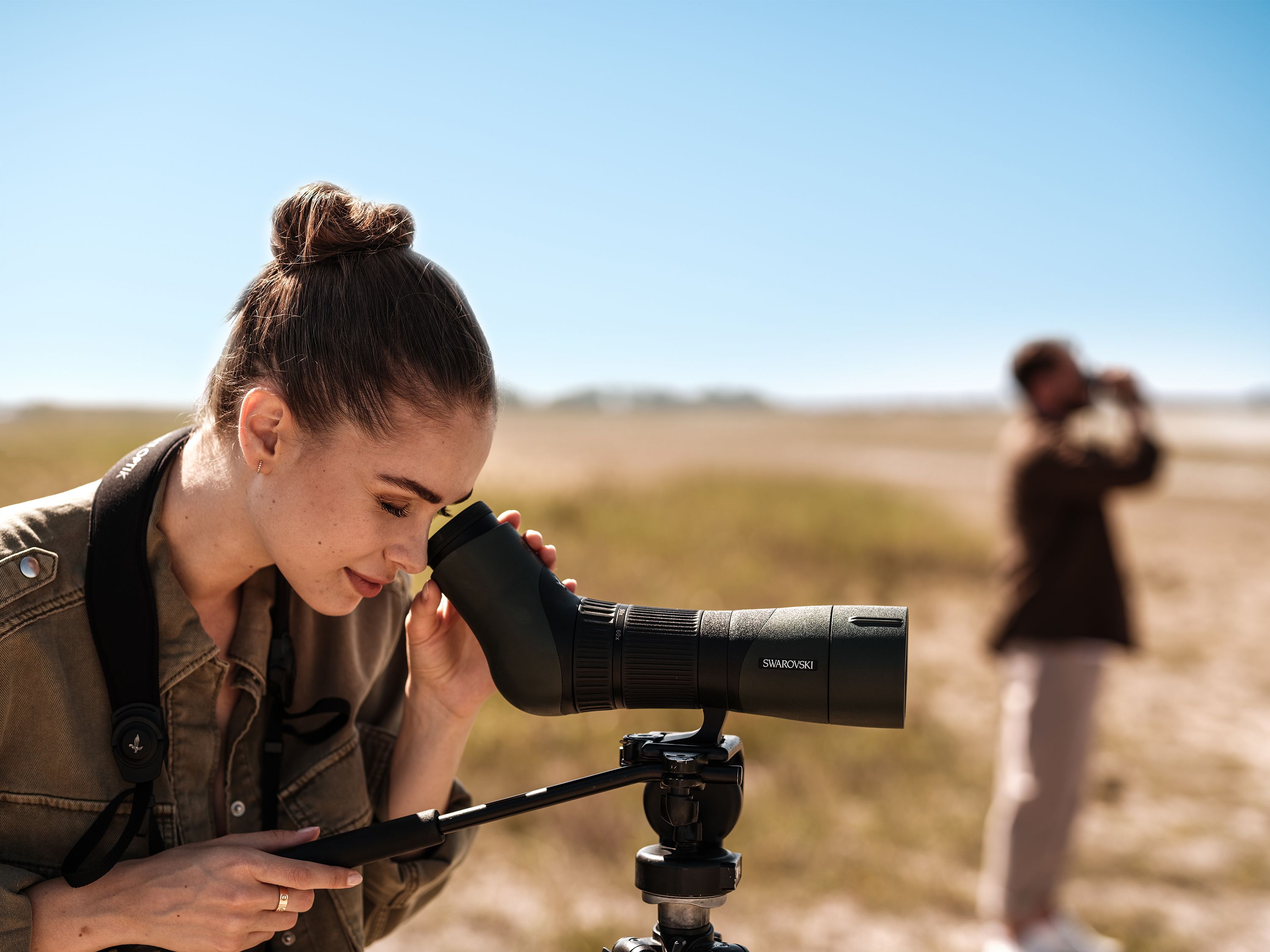 Woman looking through binoculars at St. Martins Therme & Lodge
